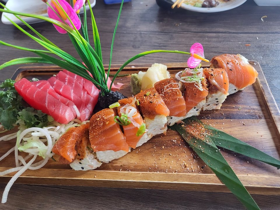 Plated sushi rolls on white dishes.
